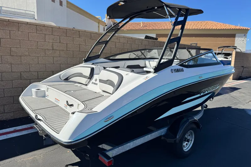 Slide: The Image of 2023 Yamaha Boats AR195, sleek design, parked on trailer, outdoor setting. - 5