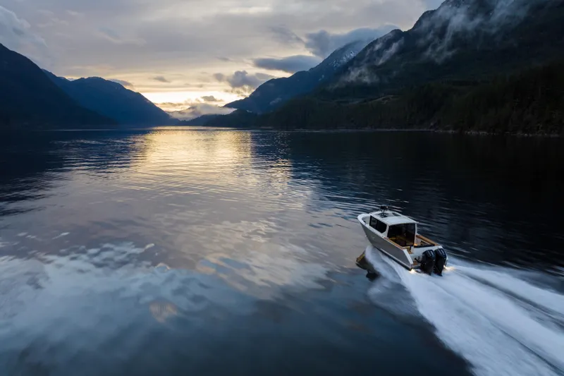 Slide: The Image of Jasper Marine Defender 22 boat, 2026 model, on serene lake with scenic mountain backdrop. - 11