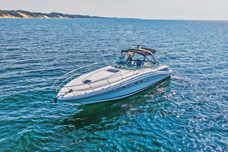 Slide: The Image of 2003 Sea Ray 420 Sundancer cruising on clear blue water under sunny skies. - 1