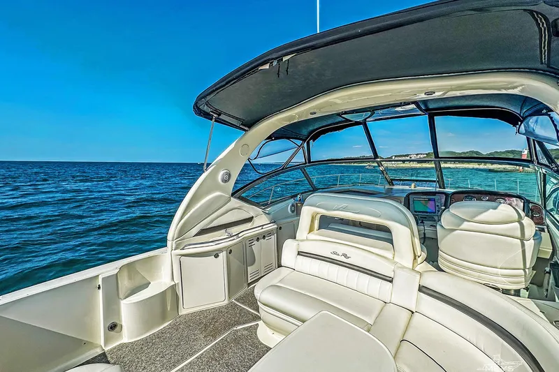 Slide: The Image of 2003 Sea Ray 420 Sundancer yacht interior with ocean view, featuring luxurious seating and navigation equipment. - 15