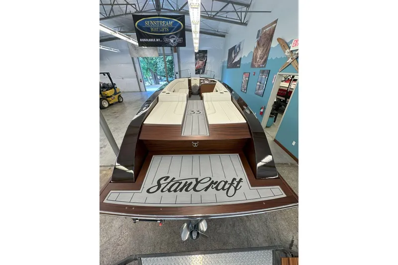 Slide: The Image of 2025 StanCraft 260 Day Boat in showroom, featuring elegant wood finish and spacious seating. - 4