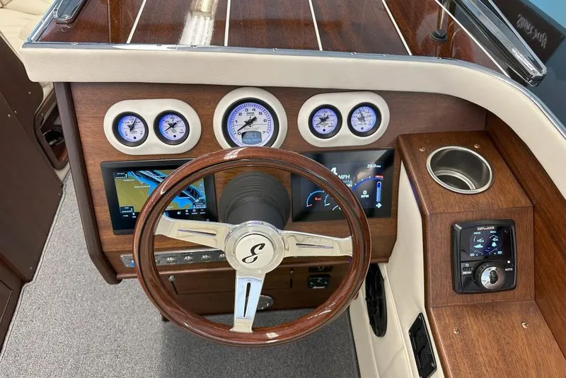 Slide: The Image of 2025 StanCraft 260 Day Boat dashboard with wood finish, gauges, and steering wheel. - 9