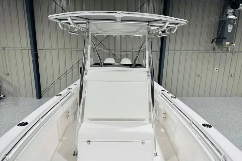 Slide: The Image of 2025 Contender 28 Tournament boat interior with T-top and seating, in a storage facility. - 10