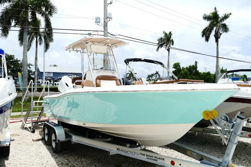 The Image of 2026 Pioneer 220 Bay Sport boat on trailer, displayed outdoors with palm trees. - 0
