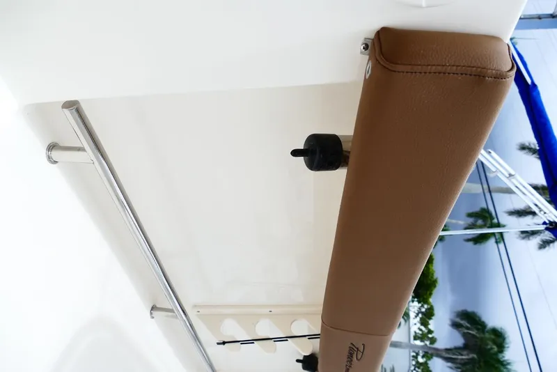 Slide: The Image of 2026 Pioneer 220 Bay Sport boat interior with brown cushioned rail and stainless steel handle. - 13