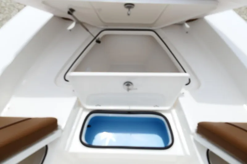 Slide: The Image of 2026 Pioneer 220 Bay Sport boat storage compartments, featuring open hatches and seating. - 23