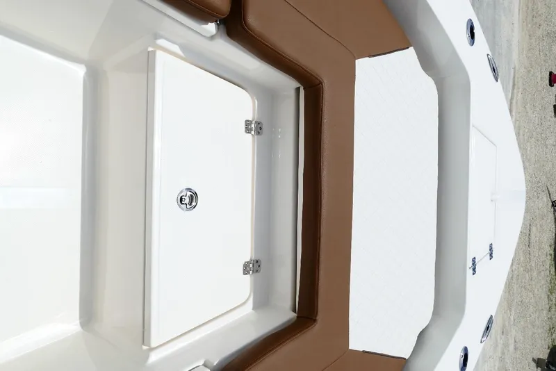 Slide: The Image of 2026 Pioneer 220 Bay Sport boat interior with brown seating and storage compartment. - 27