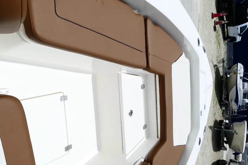 Slide: The Image of 2026 Pioneer 220 Bay Sport boat interior with brown seating and storage compartments. - 28