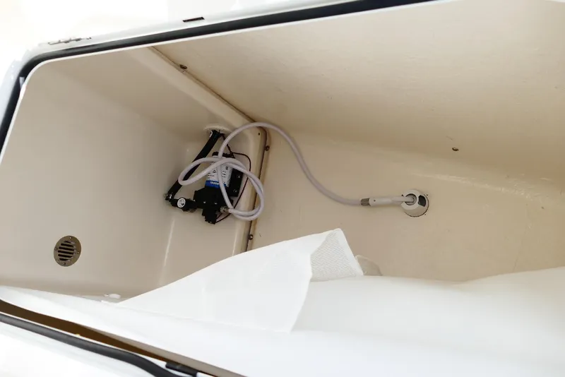 Slide: The Image of Interior view of 2026 Pioneer 220 Bay Sport boat compartment with pump and hose. - 31