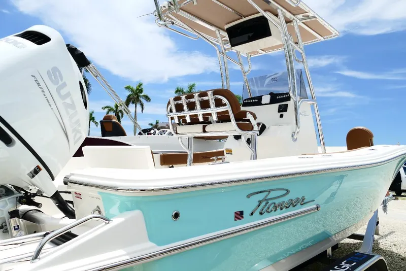 Slide: The Image of 2026 Pioneer 220 Bay Sport boat with Suzuki engine, docked under clear blue sky. - 48