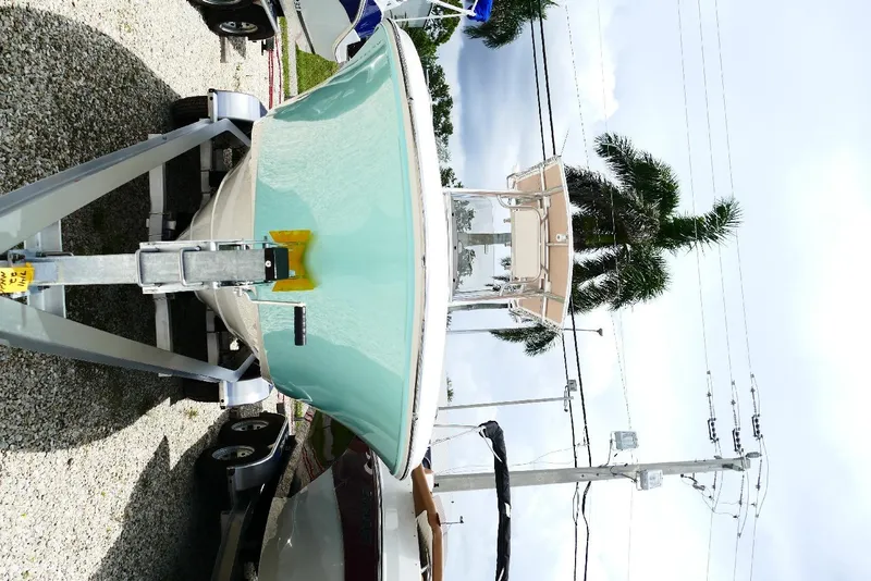 Slide: The Image of 2026 Pioneer 220 Bay Sport boat on trailer, parked outdoors near palm trees. - 52