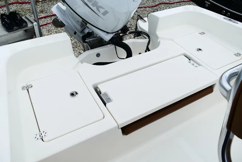 Slide: The Image of 2026 Pioneer 220 Bay Sport boat interior with Suzuki engine, featuring storage compartments. - 8