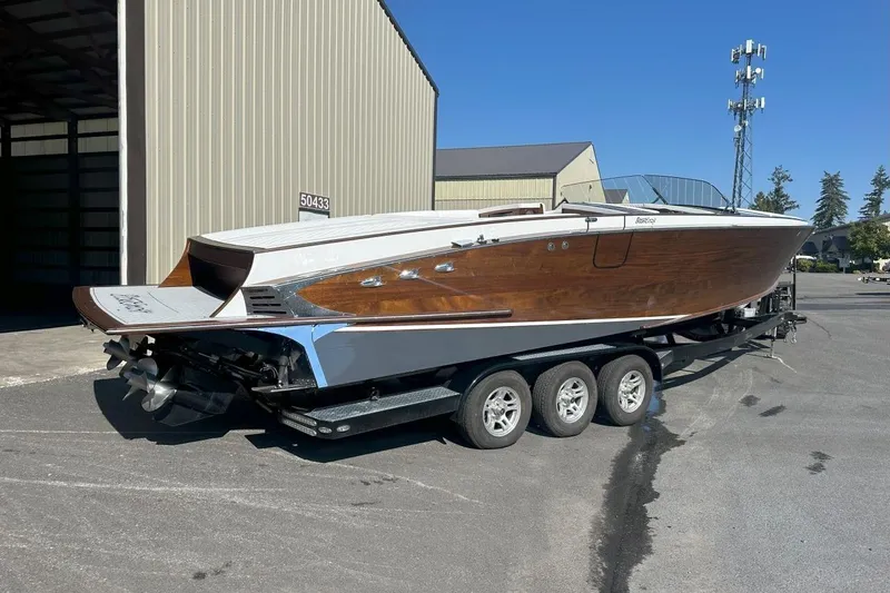 Slide: The Image of 2017 StanCraft 320 Rivelle boat on trailer, showcasing sleek wooden design and modern features. - 2