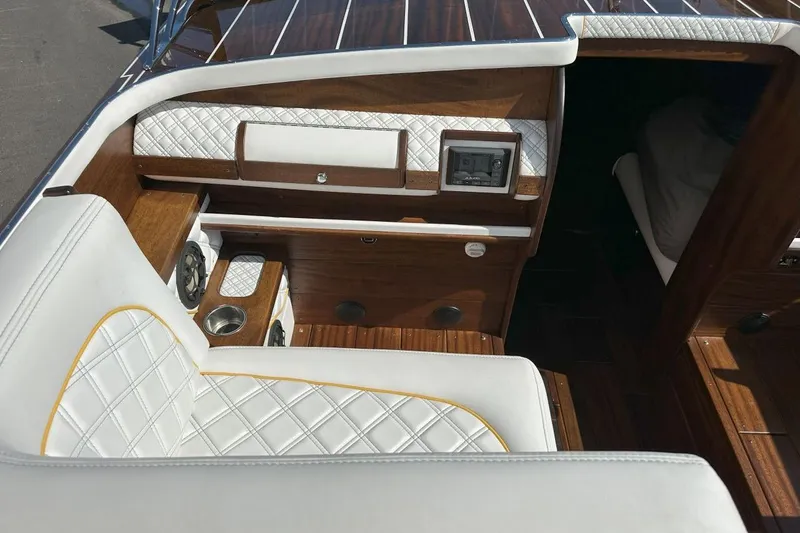 Slide: The Image of Luxurious interior of 2017 StanCraft 320 Rivelle boat with white quilted seating and wood accents. - 6