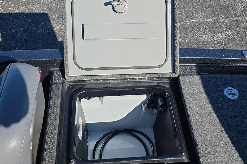 Slide: The Image of Open storage compartment on 2025 iKon VLX 21 boat, featuring secure latch and interior cables. - 13