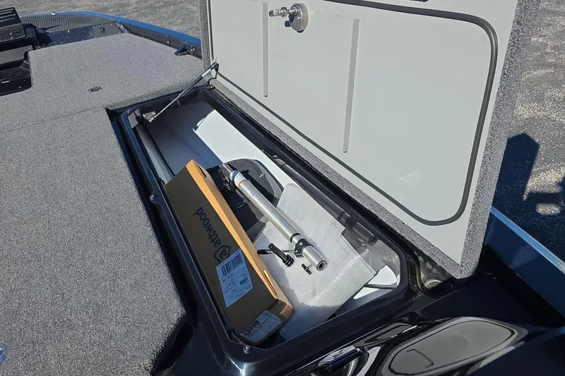 Slide: The Image of Open storage compartment in 2025 iKon VLX 21 boat, showing equipment and packaging. - 16