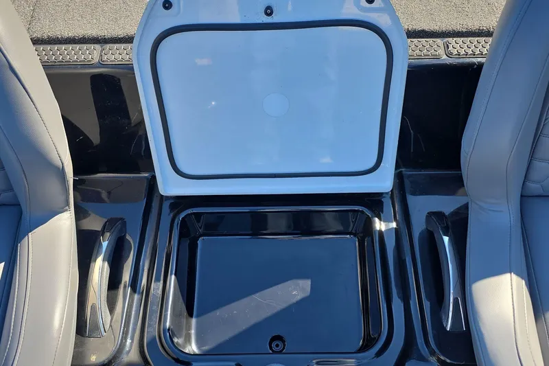 Slide: The Image of Open storage compartment in 2025 iKon VLX 21 boat, between two gray seats. - 9