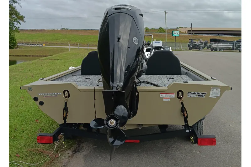 Slide: The Image of 2026 Tracker Pro Team 175 boat with outboard motor, parked on a road near grass. - 4