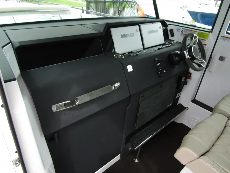 Slide: The Image of 2024 Axopar 37XC CROSS CABIN helm with dual Simrad displays and modern steering wheel. - 13