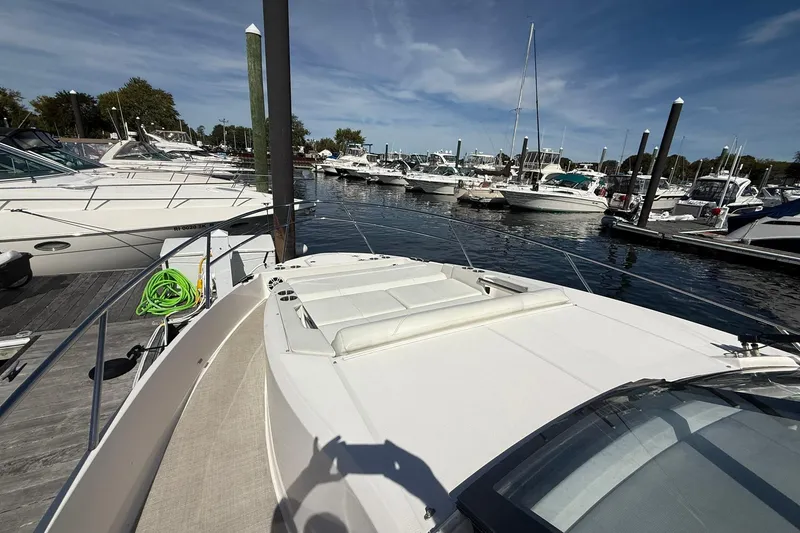 Slide: The Image of 2021 Regal 36 Grande Coupe yacht with spacious deck and inflatable boat docked. - 10