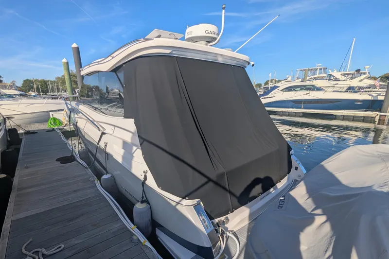 Slide: The Image of 2021 Regal 36 Grande Coupe docked at a marina with other boats. - 11