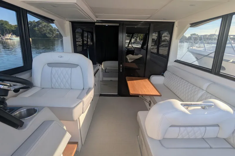 Slide: The Image of 2021 Regal 36 Grande Coupe boat with white seating, docked at marina. - 14