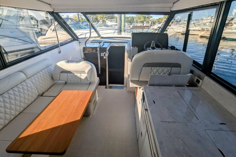 Slide: The Image of Interior of 2021 Regal 36 Grande Coupe with luxurious seating and scenic water view. - 15