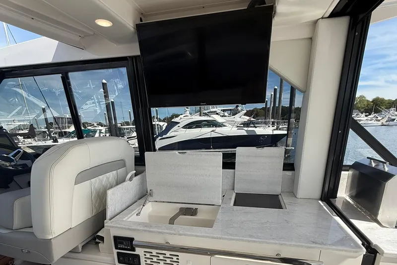 Slide: The Image of 2021 Regal 36 Grande Coupe interior with luxurious seating and waterfront view. - 23