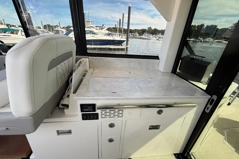 Slide: The Image of Interior of 2021 Regal 36 Grande Coupe yacht with white seating and cabinetry. - 25