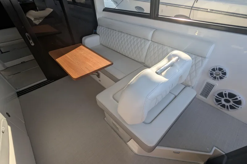 Slide: The Image of 2021 Regal 36 Grande Coupe interior with sleek seating and modern countertop, overlooking marina. - 26