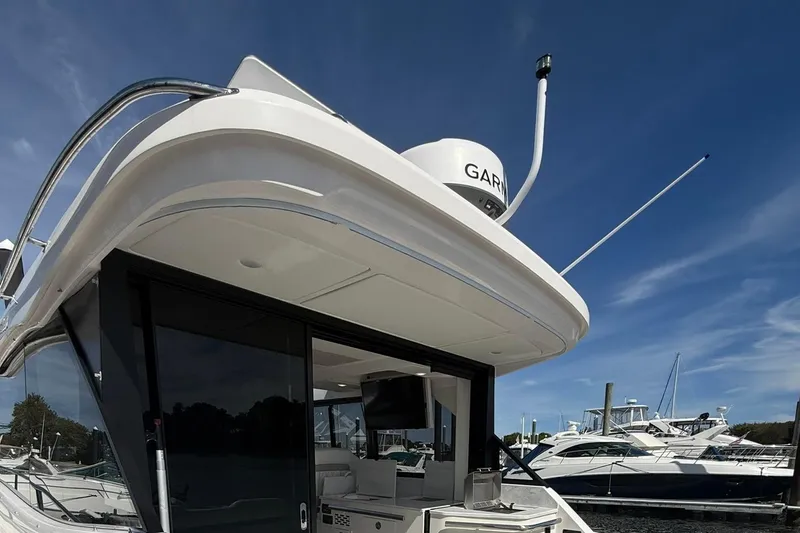 Slide: The Image of 2021 Regal 36 Grande Coupe yacht with luxurious seating and sleek design at a marina. - 8