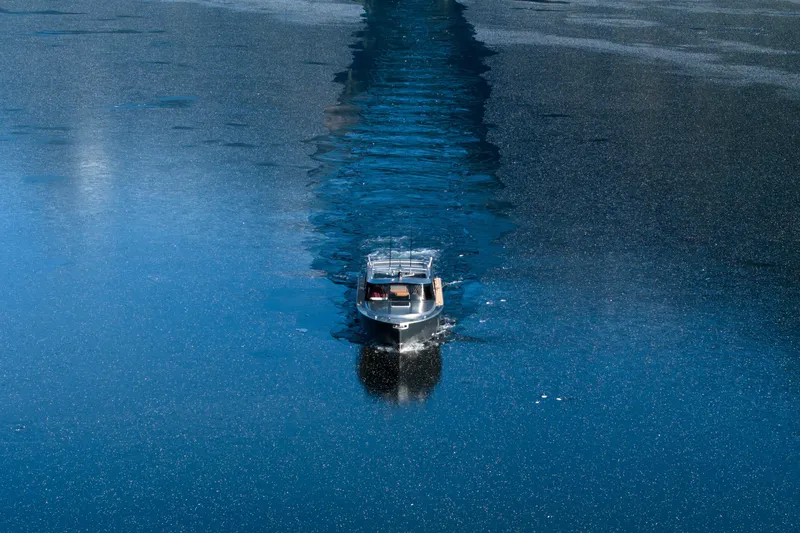 Slide: The Image of Jasper Marine Defender 22 boat cruising on a serene lake at sunset, 2026 model. - 14