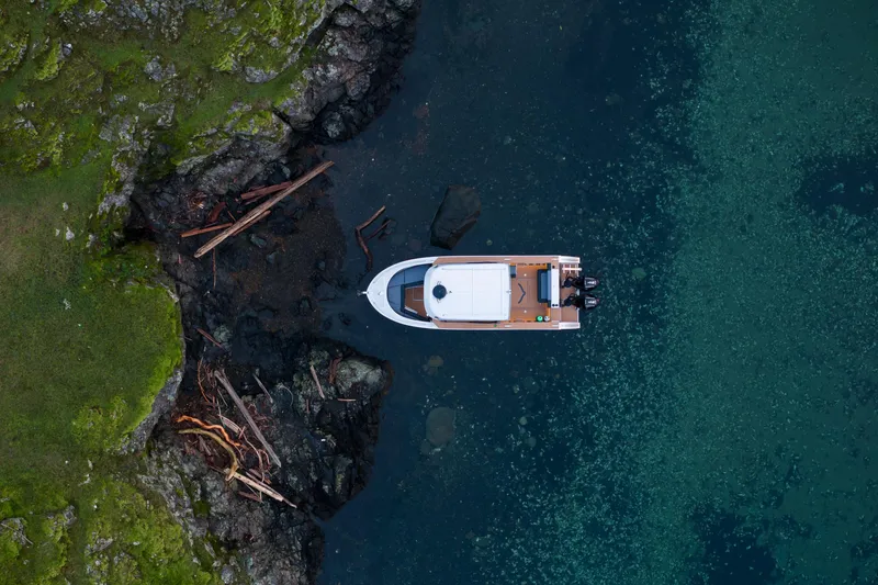 Slide: The Image of 2026 Jasper Marine Defender 22 cruising on a serene lake with mountainous backdrop. - 9