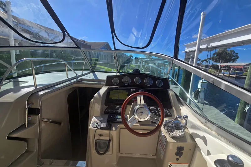 Slide: The Image of Cockpit view of 2010 Sea Ray 330 Sundancer, showcasing steering wheel and control panel. - 25
