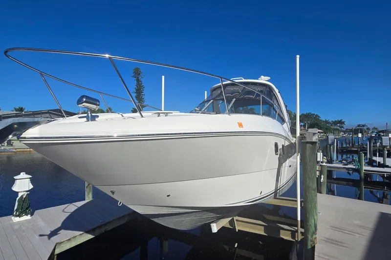 Slide: The Image of 2010 Sea Ray 330 Sundancer boat docked under clear blue sky. - 3