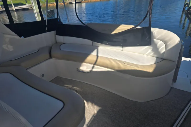 Slide: The Image of 2010 Sea Ray 330 Sundancer interior with beige seating, overlooking calm waters. - 33