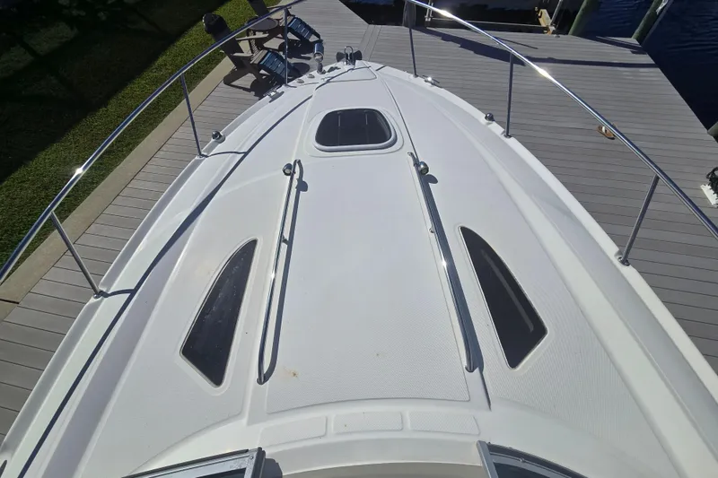 Slide: The Image of 2010 Sea Ray 330 Sundancer boat deck with sleek design and railing. - 38
