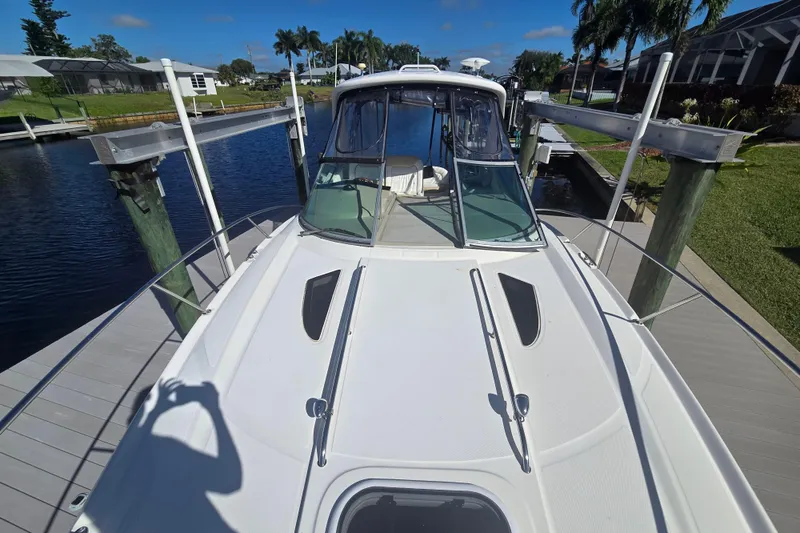 Slide: The Image of 2010 Sea Ray 330 Sundancer docked, viewed from the bow, with clear skies and lush surroundings. - 40