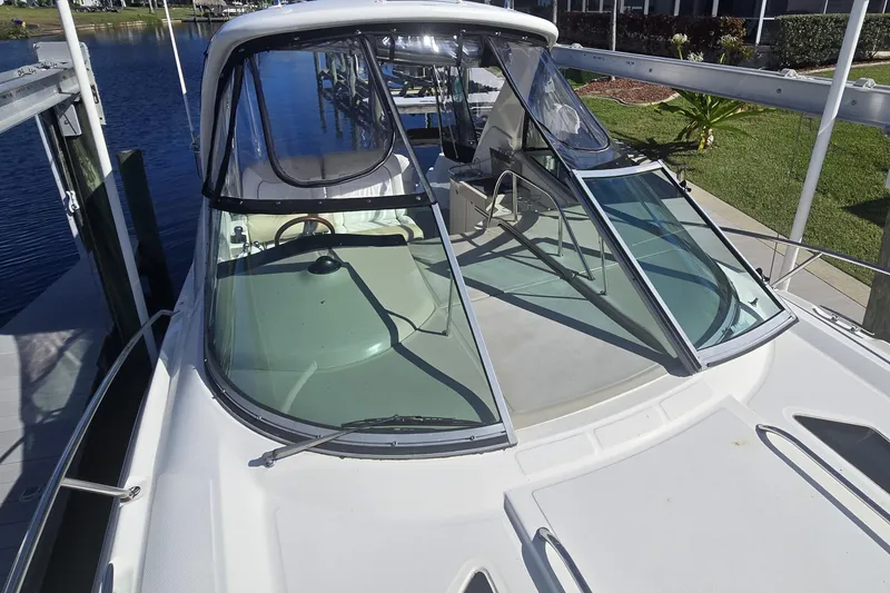 Slide: The Image of 2010 Sea Ray 330 Sundancer boat docked, showcasing sleek design and spacious deck. - 42