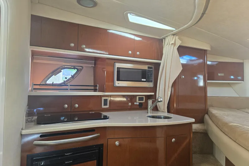 Slide: The Image of Interior of 2010 Sea Ray 330 Sundancer with kitchenette, microwave, and cozy sleeping area. - 46