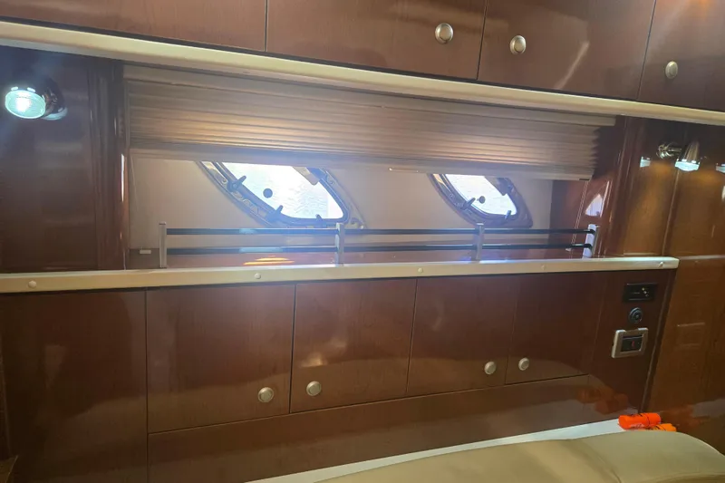 Slide: The Image of Interior of 2010 Sea Ray 330 Sundancer with wooden cabinets and porthole windows. - 48