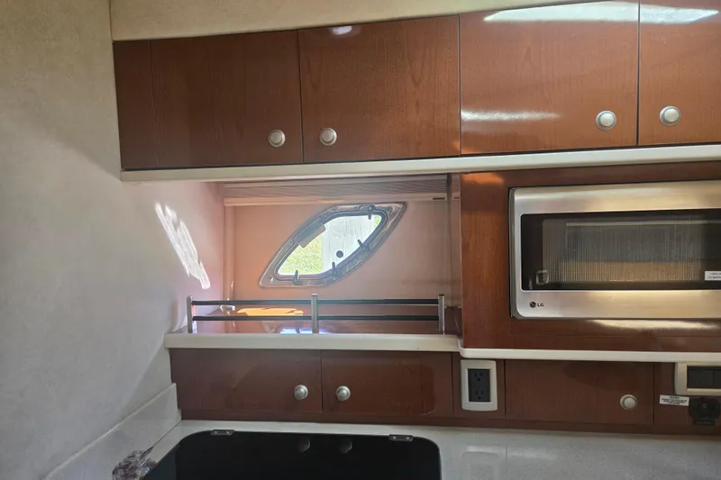 Slide: The Image of Interior of 2010 Sea Ray 330 Sundancer with wooden cabinets and microwave. - 49