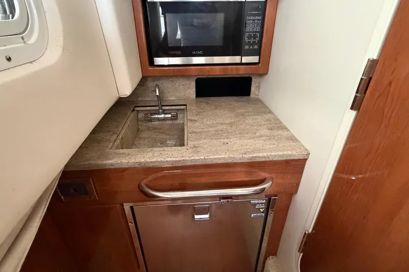 Slide: The Image of 2017 Formula 350 Crossover Bowrider kitchenette with sink, microwave, and mini-fridge. - 18