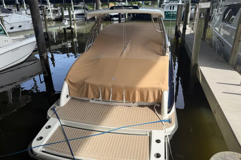 Slide: The Image of 2017 Formula 350 Crossover Bowrider docked with tan cover, rear view. - 2