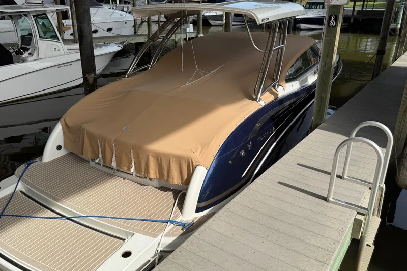 Slide: The Image of 2017 Formula 350 Crossover Bowrider docked with tan cover, marina setting. - 3