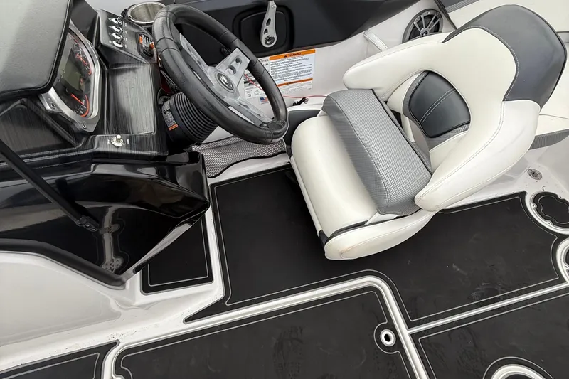 Slide: The Image of Interior of a 2019 Scarab 195G boat showing steering wheel and cushioned seat. - 10