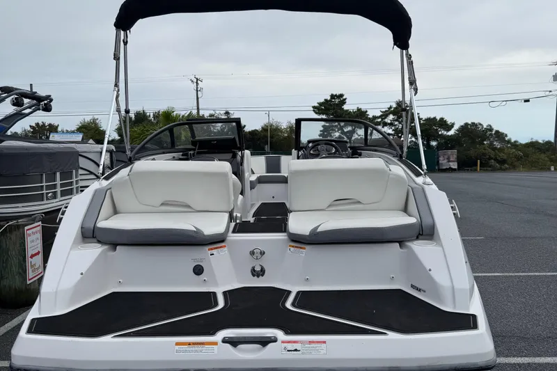 Slide: The Image of 2019 Scarab 195G boat with white seating and black canopy in a parking lot. - 5