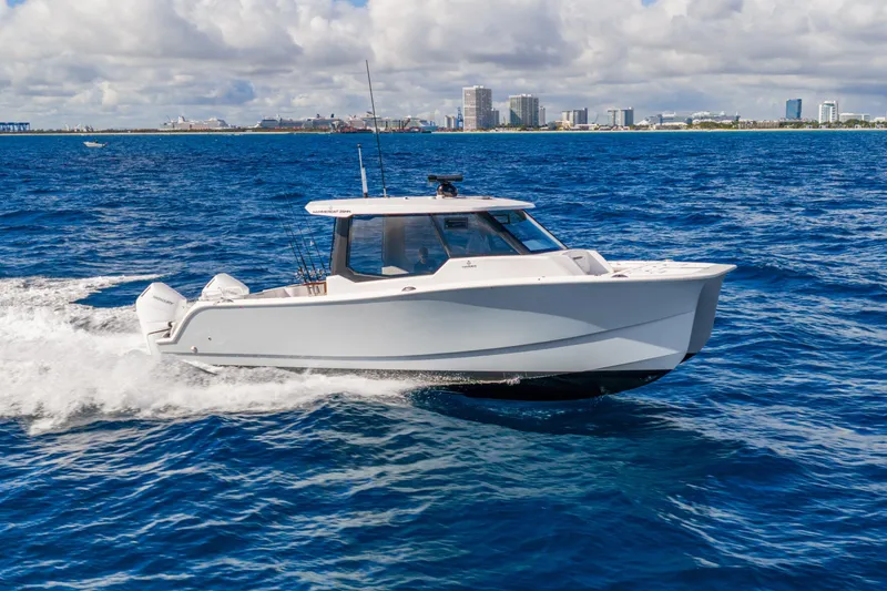 Slide: The Image of 2026 Hammer Yachts 35HH cruising on blue ocean near city skyline. - 2