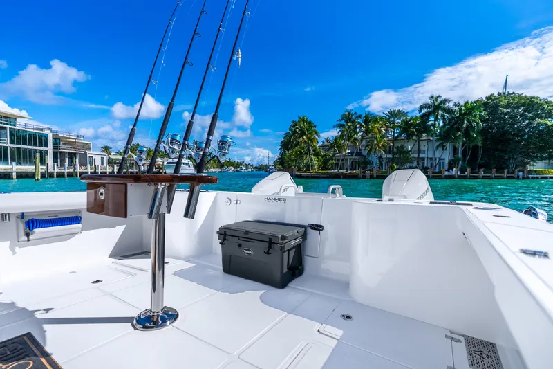 Slide: The Image of 2026 Hammer Yachts 35HH boat with fishing rods, docked by tropical waterfront. - 35
