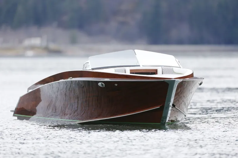 Slide: The Image of 2025 StanCraft 290 Rivelle boat on calm water, showcasing sleek wooden design. - 0